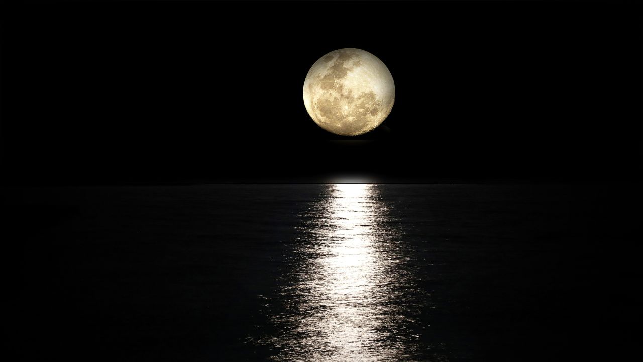 beautiful full moon shining over the water